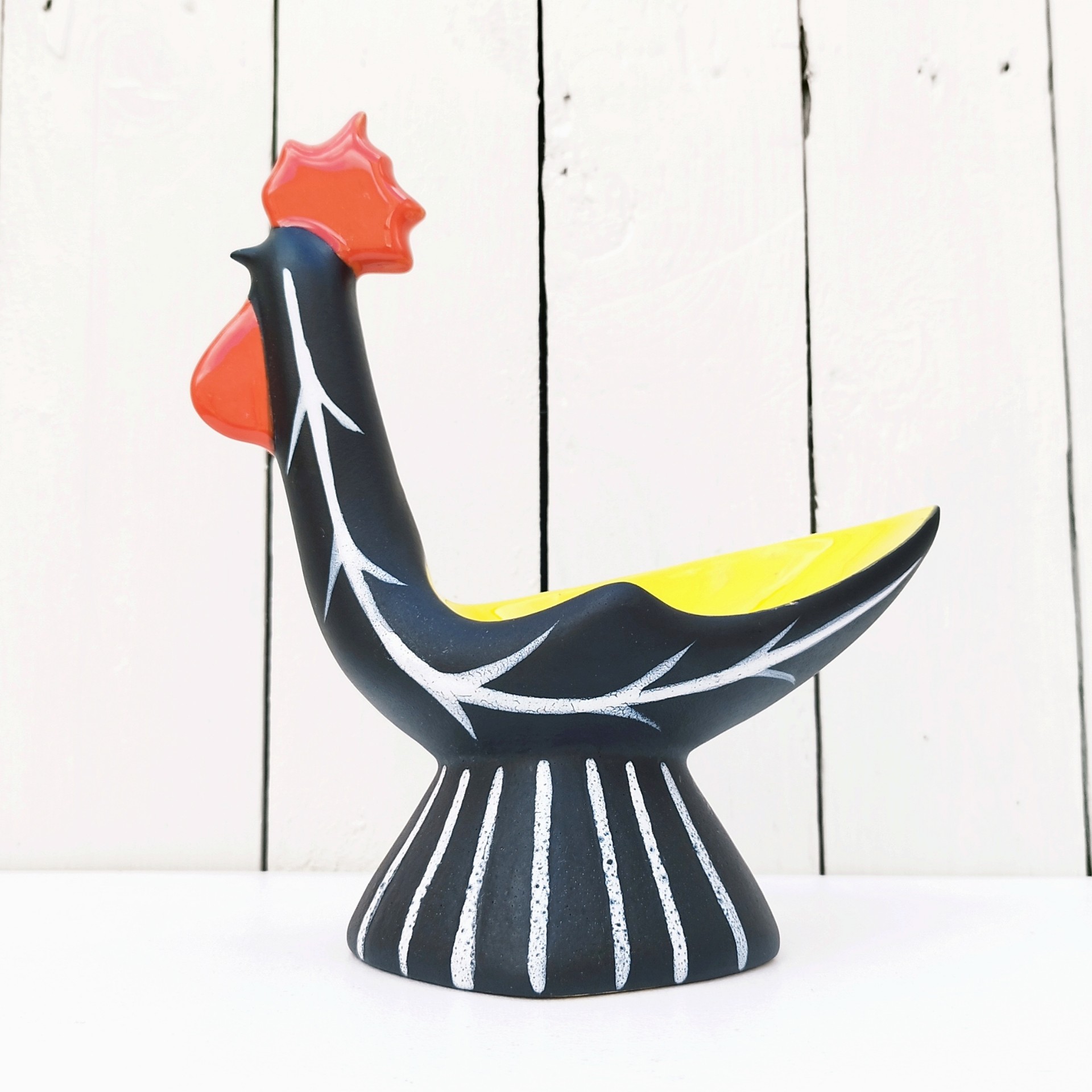 Vide poche en céramique antropomorphe représentant un coq, datant des années 50. Une micro égrenure sur le haut de la crête. Très bon état. Hauteur : 22 cm Dimensions : 19,5 x  9 cm