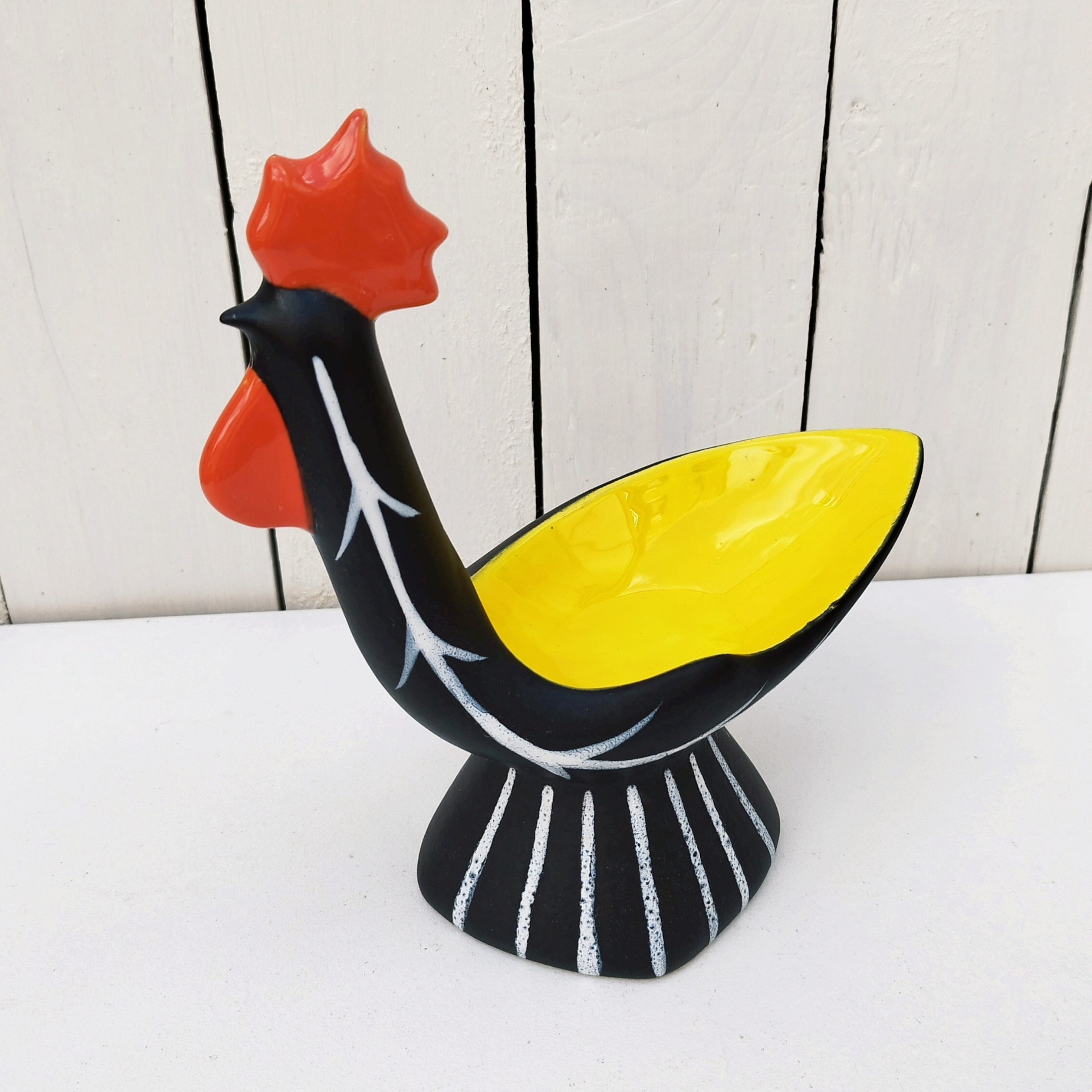 Vide poche en céramique antropomorphe représentant un coq, datant des années 50. Une micro égrenure sur le haut de la crête. Très bon état. Hauteur : 22 cm Dimensions : 19,5 x  9 cm