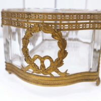 Centre de table à la forme de jardinière, structure en bronze et bac en verre . De style Louis XVI. Des petites rayures d'usage Il sera d'un plus bel effet sur une table. Bon état général. Dimensions : 20 x 10,5 x 8 cm