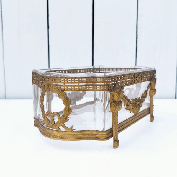 Centre de table à la forme de jardinière, structure en bronze et bac en verre . De style Louis XVI. Des petites rayures d'usage Il sera d'un plus bel effet sur une table. Bon état général. Dimensions : 20 x 10,5 x 8 cm