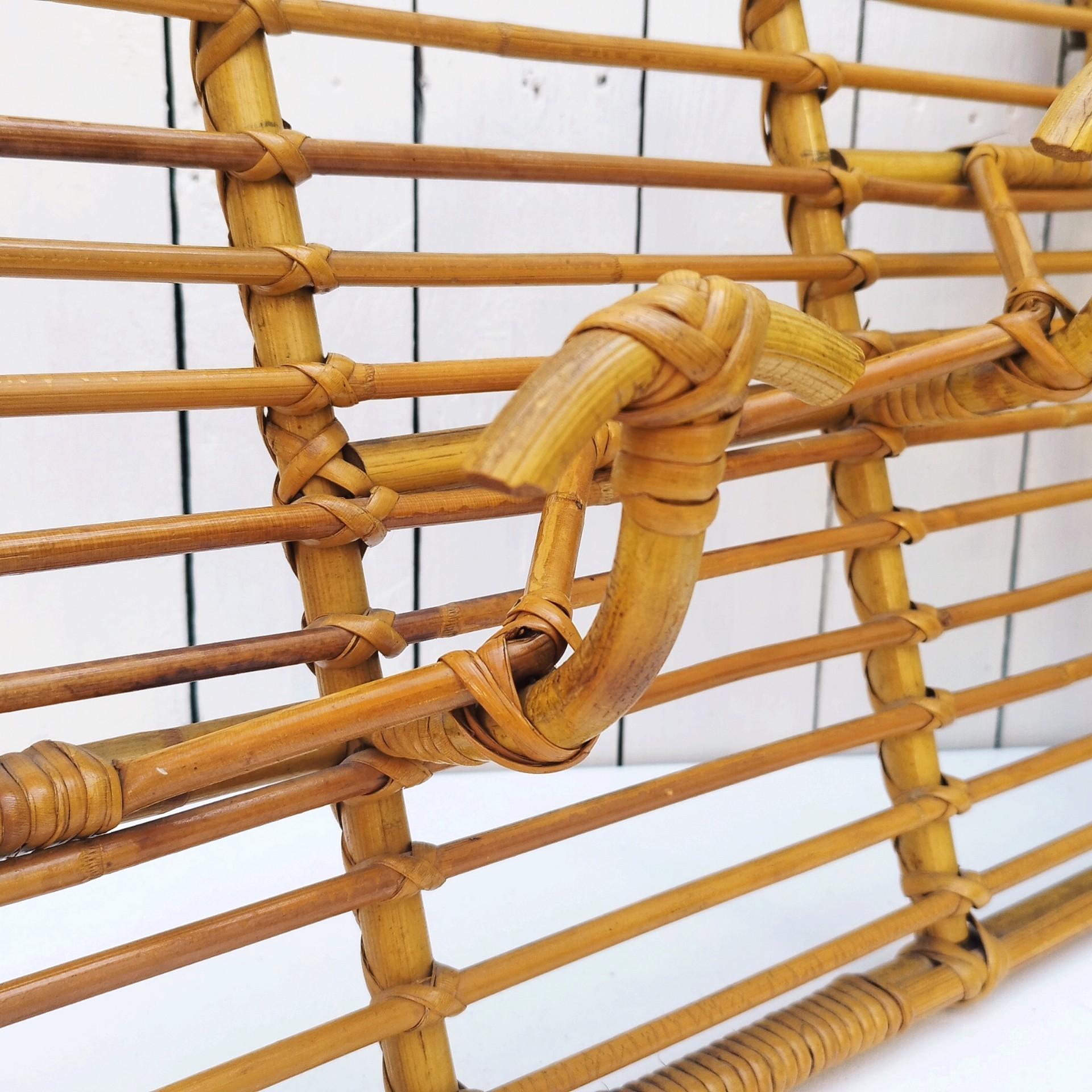 Grand porte-manteaux en rotin, 4 patères. Datant des années 60. Deux accroches murales. Manque un lien sur le coté gauche au niveau de la patère, a été refixé avec une pointe et collé. Bon état général. Longueur : 75 cm hauteur max : 40 cm Hauteur min : 30 cm