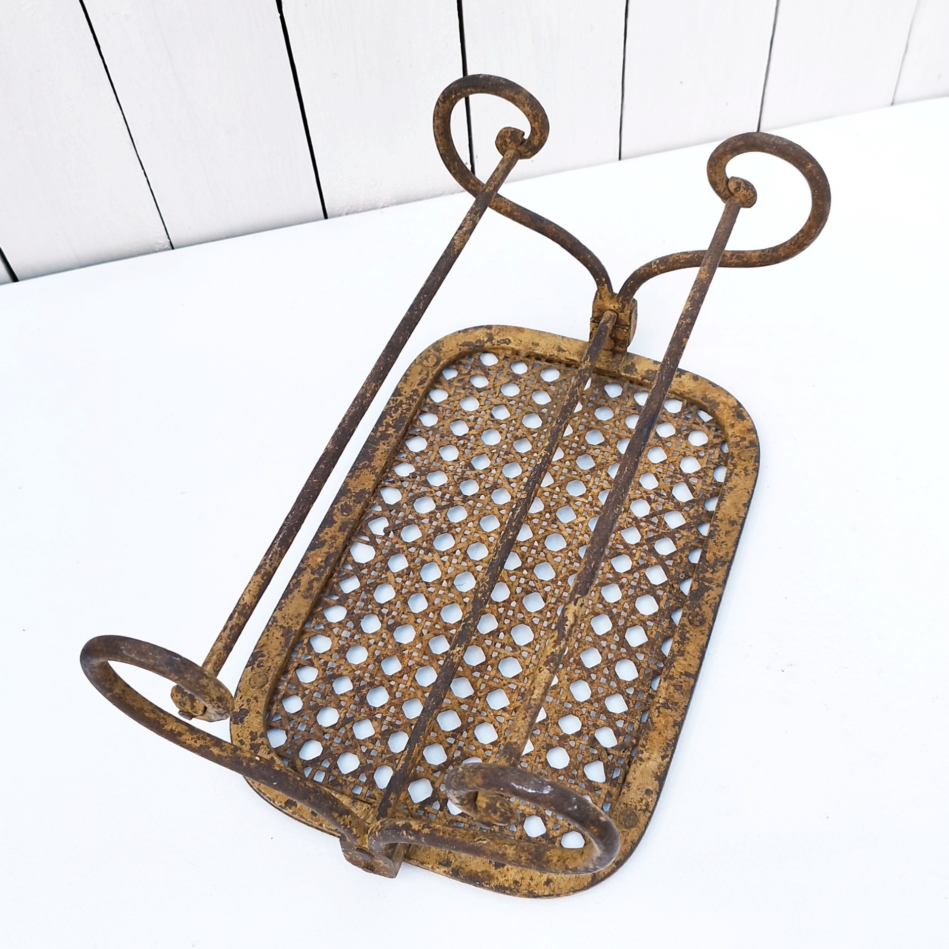 Ancien repose pieds amovible en fer forgé, avec imitation cannage aussi en fer forgé. Très beau travail et de belle qualité. Corrosion sur tout le repose pieds n'altérant pas sa stabilité et robustesse. Dans son jus , bon état général. Hauteur : 16,5 cm Dimensions repose pieds : 20 x 32,5 cm