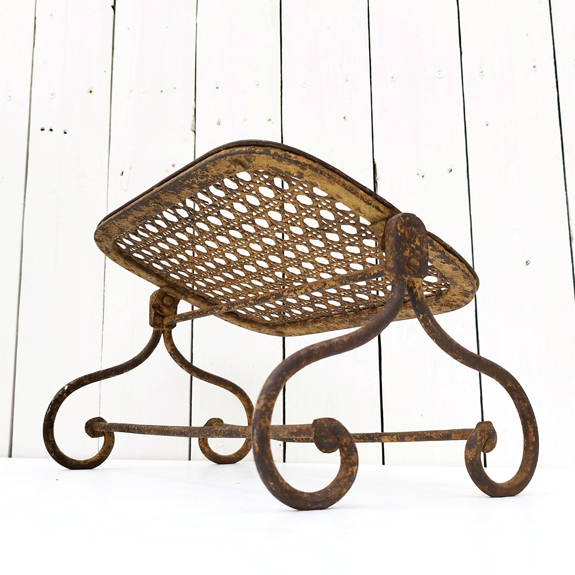 Ancien repose pieds amovible en fer forgé, avec imitation cannage aussi en fer forgé. Très beau travail et de belle qualité. Corrosion sur tout le repose pieds n'altérant pas sa stabilité et robustesse. Dans son jus , bon état général. Hauteur : 16,5 cm Dimensions repose pieds : 20 x 32,5 cm