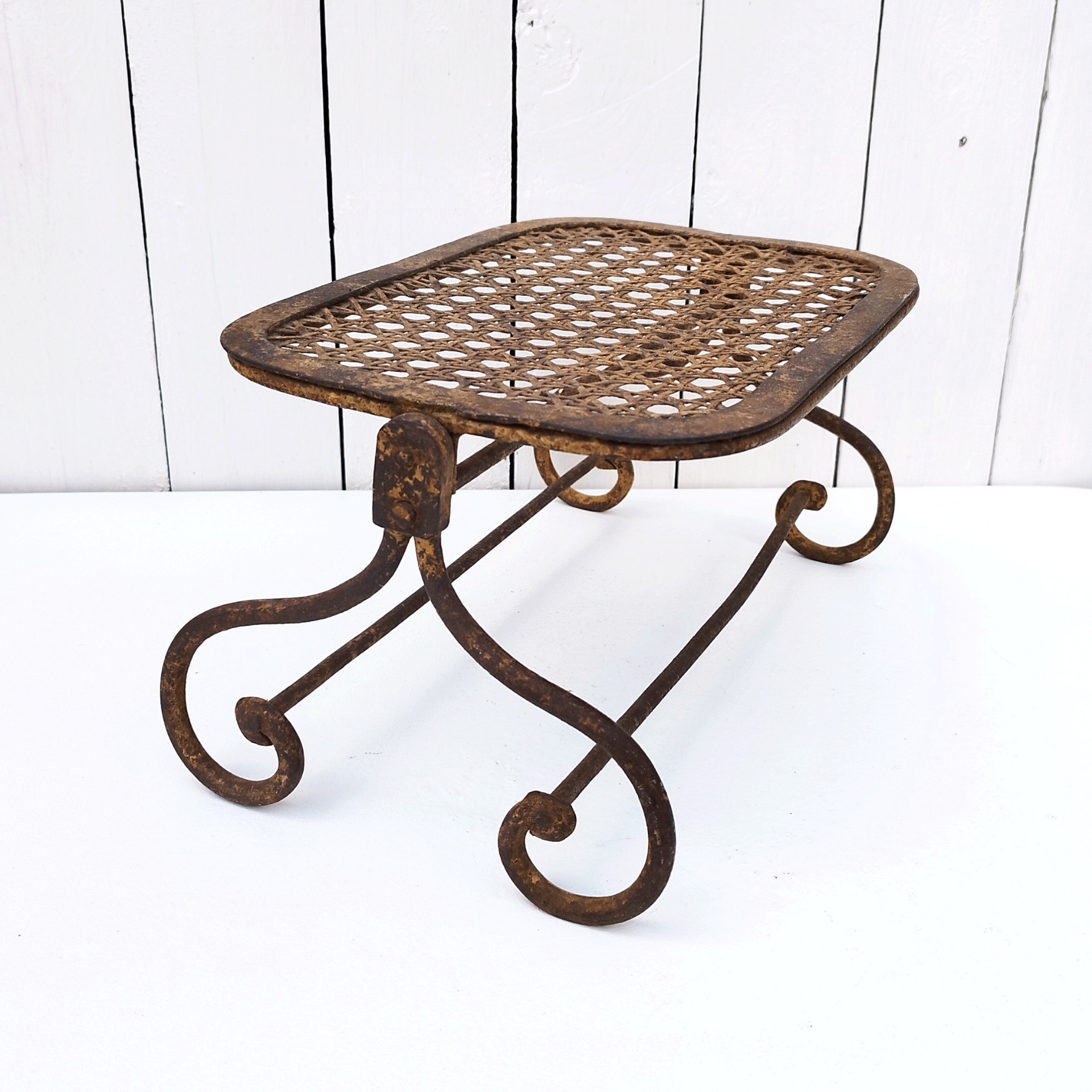 Ancien repose pieds amovible en fer forgé, avec imitation cannage aussi en fer forgé. Très beau travail et de belle qualité. Corrosion sur tout le repose pieds n'altérant pas sa stabilité et robustesse. Dans son jus , bon état général. Hauteur : 16,5 cm Dimensions repose pieds : 20 x 32,5 cm