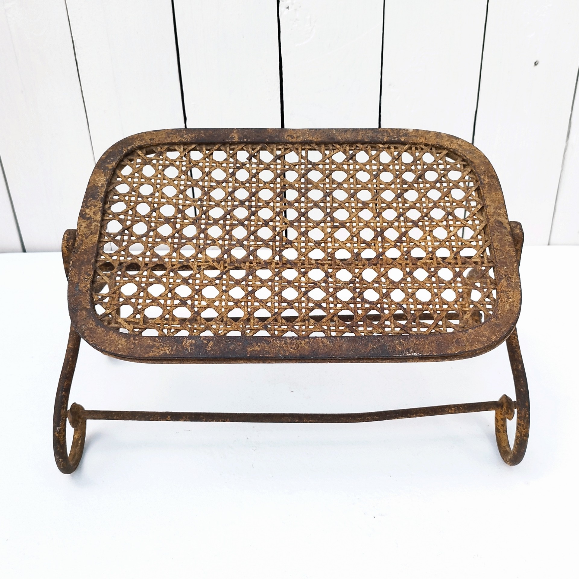 Ancien repose pieds amovible en fer forgé, avec imitation cannage aussi en fer forgé. Très beau travail et de belle qualité. Corrosion sur tout le repose pieds n'altérant pas sa stabilité et robustesse. Dans son jus , bon état général. Hauteur : 16,5 cm Dimensions repose pieds : 20 x 32,5 cm