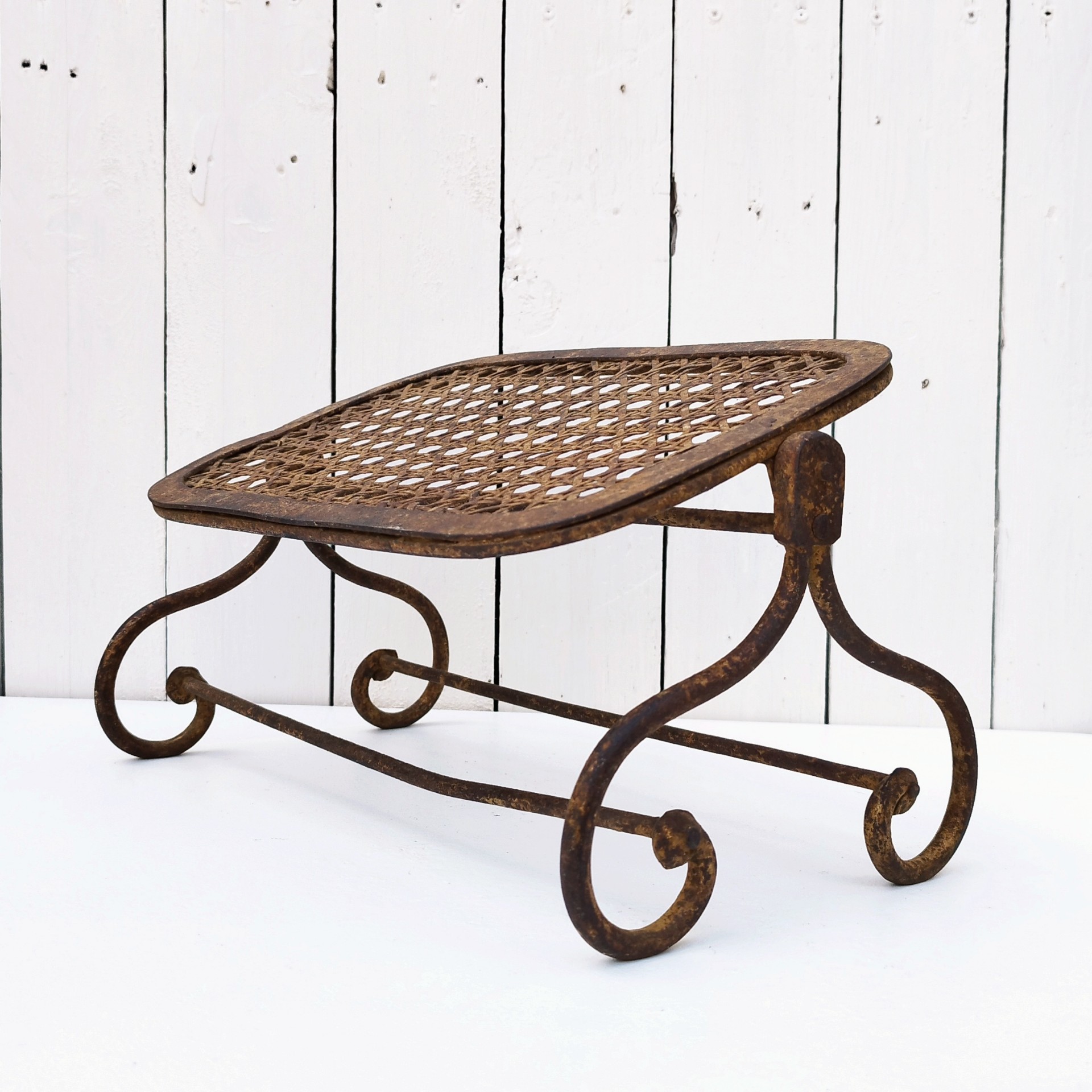 Ancien repose pieds amovible en fer forgé, avec imitation cannage aussi en fer forgé. Très beau travail et de belle qualité. Corrosion sur tout le repose pieds n'altérant pas sa stabilité et robustesse. Dans son jus , bon état général. Hauteur : 16,5 cm Dimensions repose pieds : 20 x 32,5 cm