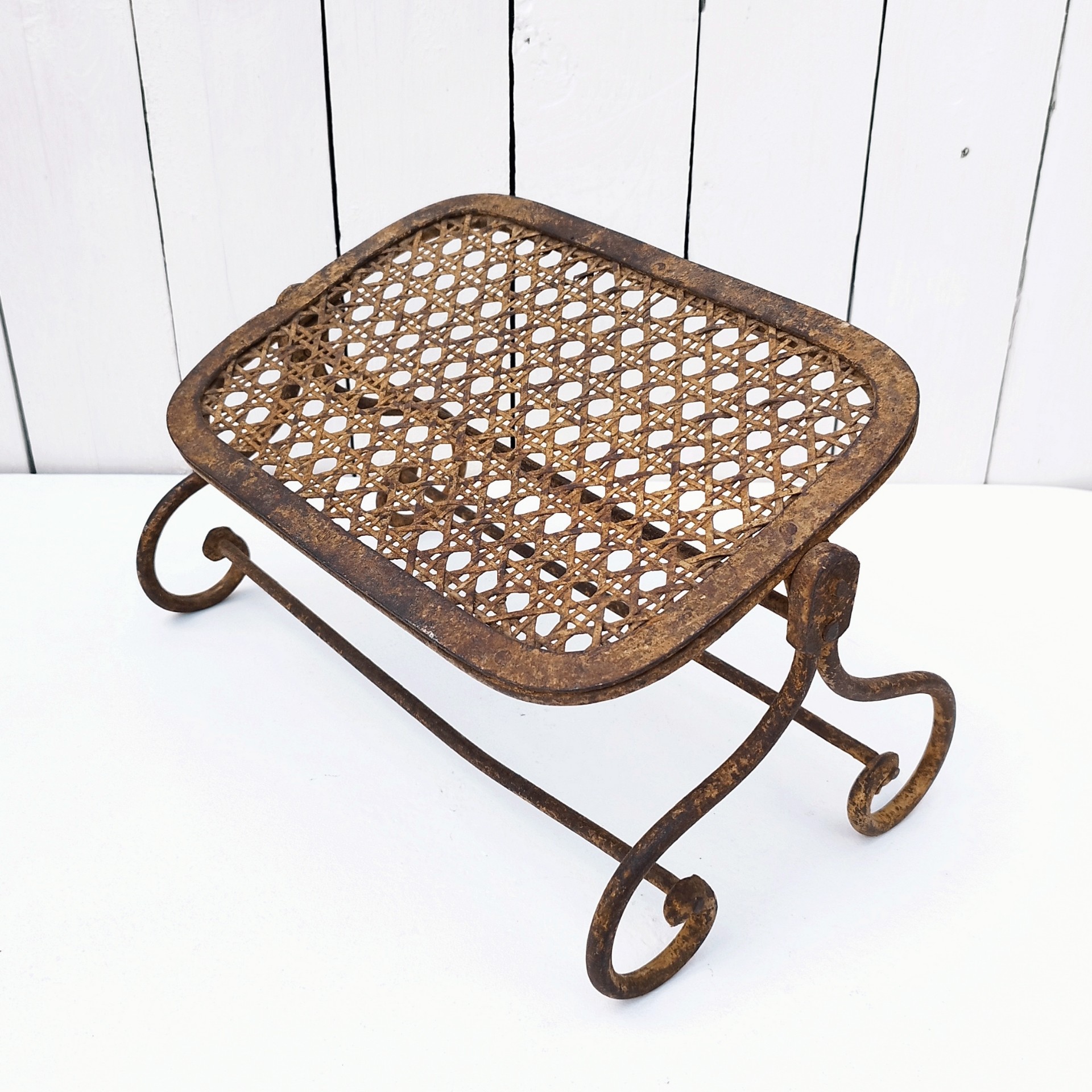 Ancien repose pieds amovible en fer forgé, avec imitation cannage aussi en fer forgé. Très beau travail et de belle qualité. Corrosion sur tout le repose pieds n'altérant pas sa stabilité et robustesse. Dans son jus , bon état général. Hauteur : 16,5 cm Dimensions repose pieds : 20 x 32,5 cm