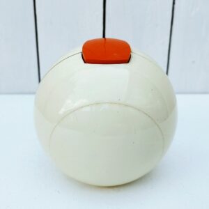 Réveil boule datant des années 70  en plastique blanc/crème et cadran orange Fonctionnne parfaitement, sonnerie pas trop agressive. Aiguilles et numérotations phosphorescentes Quelques rayures d'usage. Excellent état. Hauteur : ~ 13 cm