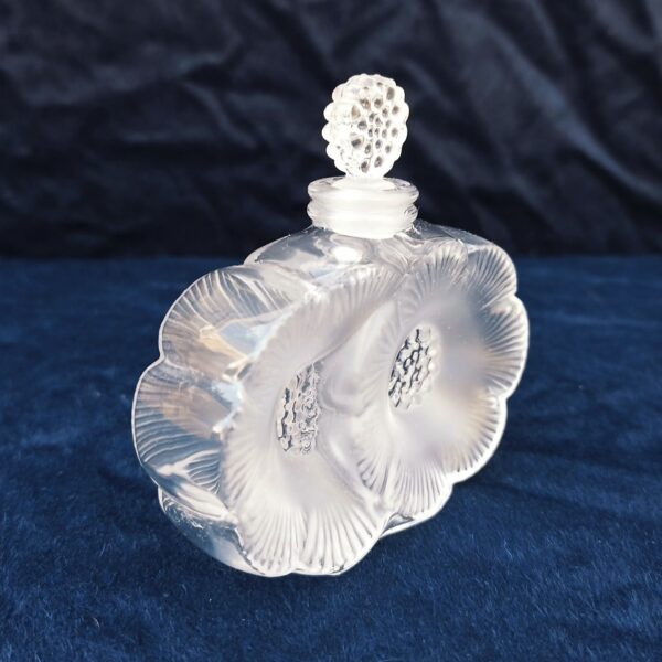 Flacon de parfum , modèle " les deux fleurs", dessiné par René Lalique .  Signé à la pointe sur le dessous. Excellent état. Hauteur avec bouchon : 9,5 cm Largeur : 9,5 cm