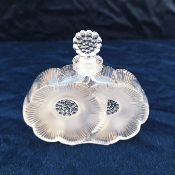 Flacon de parfum , modèle " les deux fleurs", dessiné par René Lalique .  Signé à la pointe sur le dessous. Excellent état. Hauteur avec bouchon : 9,5 cm Largeur : 9,5 cm