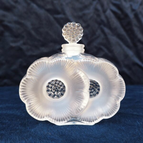 Flacon de parfum , modèle " les deux fleurs", dessiné par René Lalique .  Signé à la pointe sur le dessous. Excellent état. Hauteur avec bouchon : 9,5 cm Largeur : 9,5 cm