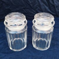 Paire de pots en verre taillé à facettes large, pouvant servir de pots à bonbons. Bouchon en verre. Des éclats sur l'intérieur d'un bouchon, non visible une fois fermé. Bon état général. Hauteur avec bouchon : 13,5 cm Diamètre : 7,5 cm