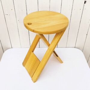  Astucieux tabouret pliant datant des années 80,  modèle "Suzy Stool "  par Adrian Reed, pour la manufacture londonienne Princes Design Works. Inspiré de la célèbre chaise à dossier TS crée par Roger Tallon. Il devient plat une fois plié et est doté d’un trou dans l'assise qui permet sa suspension et son stockage vertical. Petites traces d'usage, bon état général Hauteur : 46 cm Diamètre assise : 32cm Longueur fermé : 69  cm