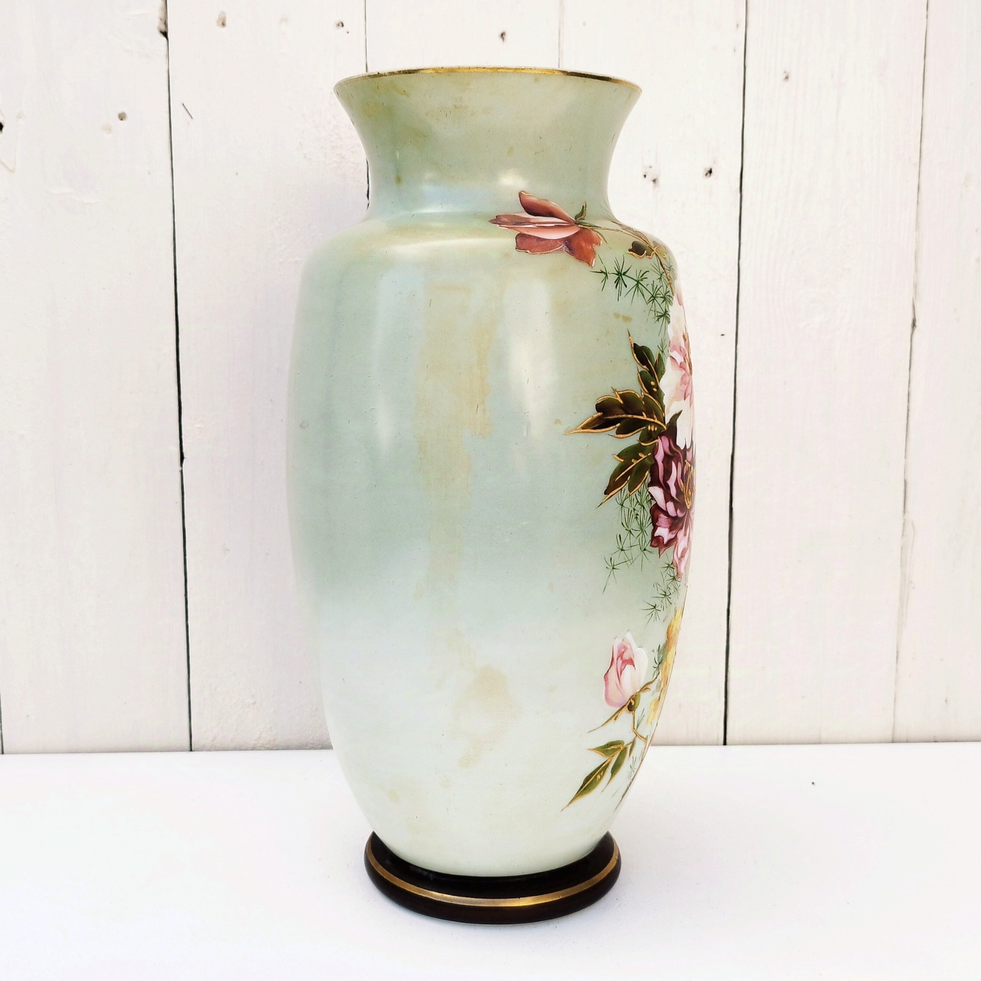 Vase balustre sur piédouche en opaline époque Napoléon III, à décor de bouquet de fleurs peints rehaussé de dorure en relief. Manque de dorure sur le col du vase, des taches de jaunissure sur le corps. Petits manques de peinture sur le piédouche. Bon état général Hauteur : 32,5 cm Diamètre col : 11,5 cm