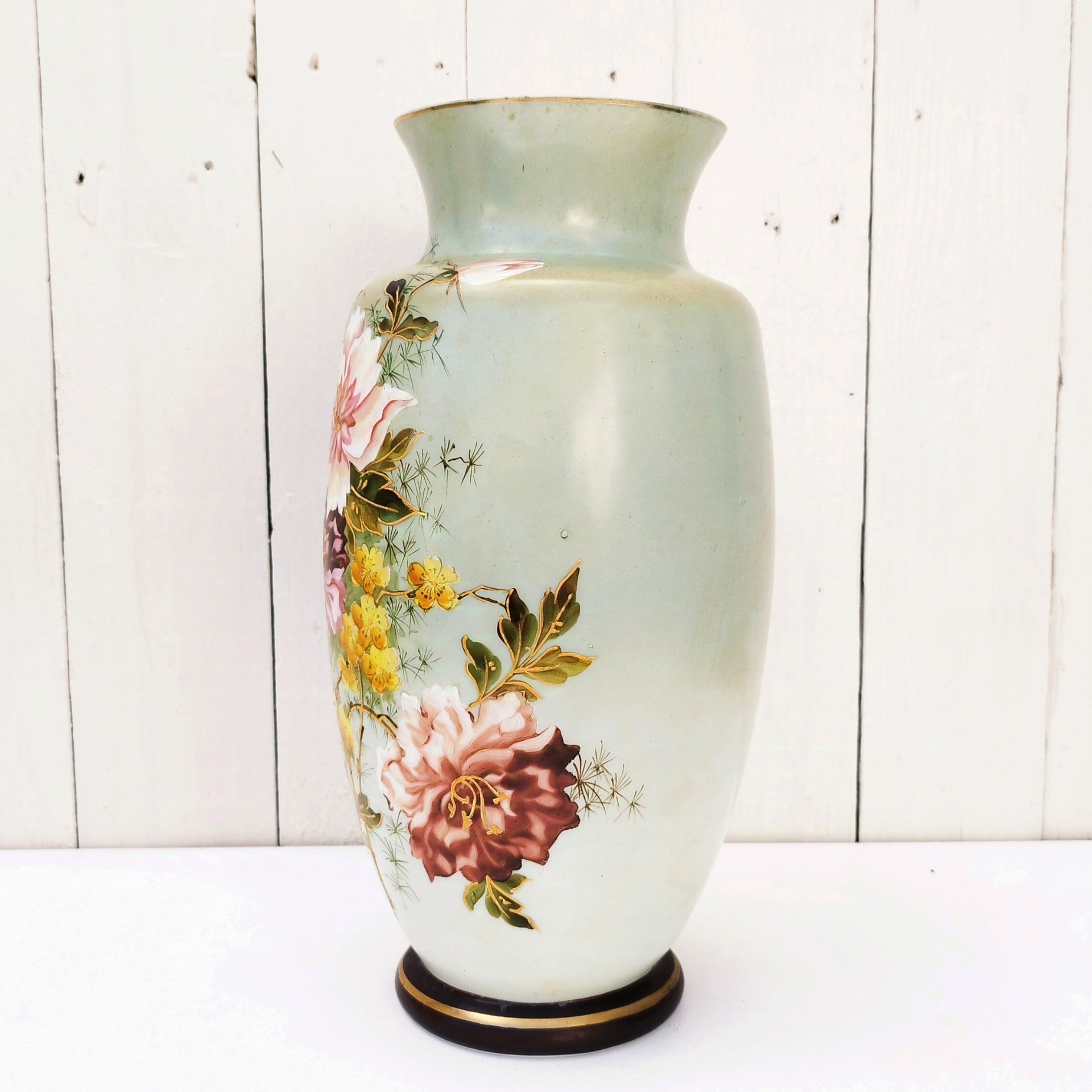 Vase balustre sur piédouche en opaline époque Napoléon III, à décor de bouquet de fleurs peints rehaussé de dorure en relief. Manque de dorure sur le col du vase, des taches de jaunissure sur le corps. Petits manques de peinture sur le piédouche. Bon état général Hauteur : 32,5 cm Diamètre col : 11,5 cm