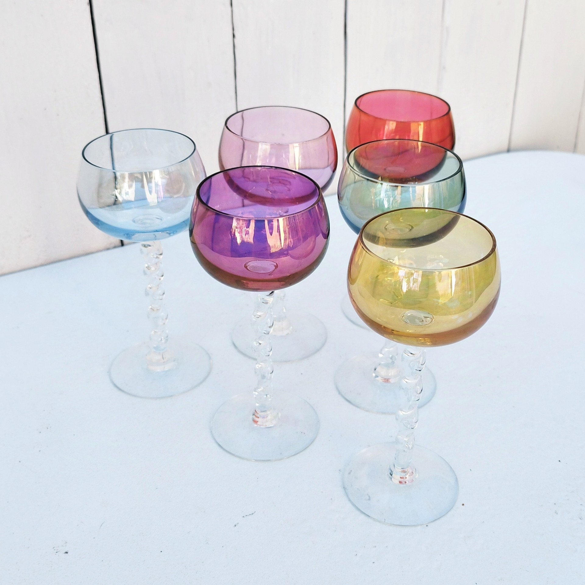 Six  verres à vin blanc colorés forme ballon et pied torsadés. Parfait pour une belle table de fête. Une égrenure sur le rebord du rose pale Hauteur : 14 cm Diamètre : 5,5 cm Capacité : 8 cl