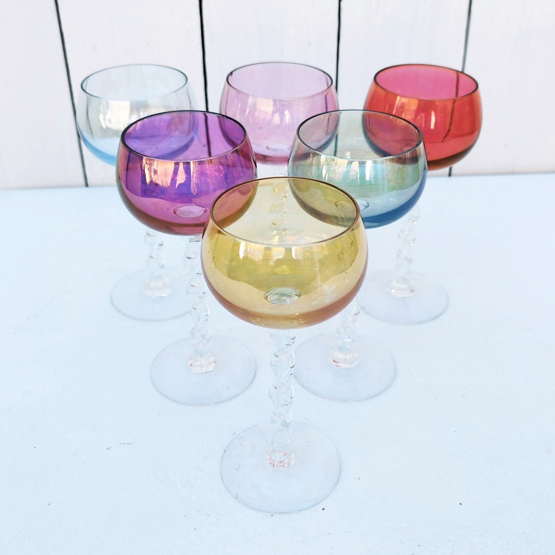 Six  verres à vin blanc colorés forme ballon et pied torsadés. Parfait pour une belle table de fête. Une égrenure sur le rebord du rose pale Hauteur : 14 cm Diamètre : 5,5 cm Capacité : 8 cl
