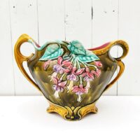 Ancien cache pot en barbotine d'onnaing modèle " Clochettes" , numéroté 739 sur le dessous. Décor de fleurs Fuchsias. Quelques micros égrenures sur le rebord. Bon état général Hauteur max : 23 cm Largeur : 22 cm Longueur max : 31 cm