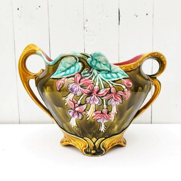 Ancien cache pot en barbotine d'onnaing modèle " Clochettes" , numéroté 739 sur le dessous. Décor de fleurs Fuchsias. Quelques micros égrenures sur le rebord. Bon état général Hauteur max : 23 cm Largeur : 22 cm Longueur max : 31 cm