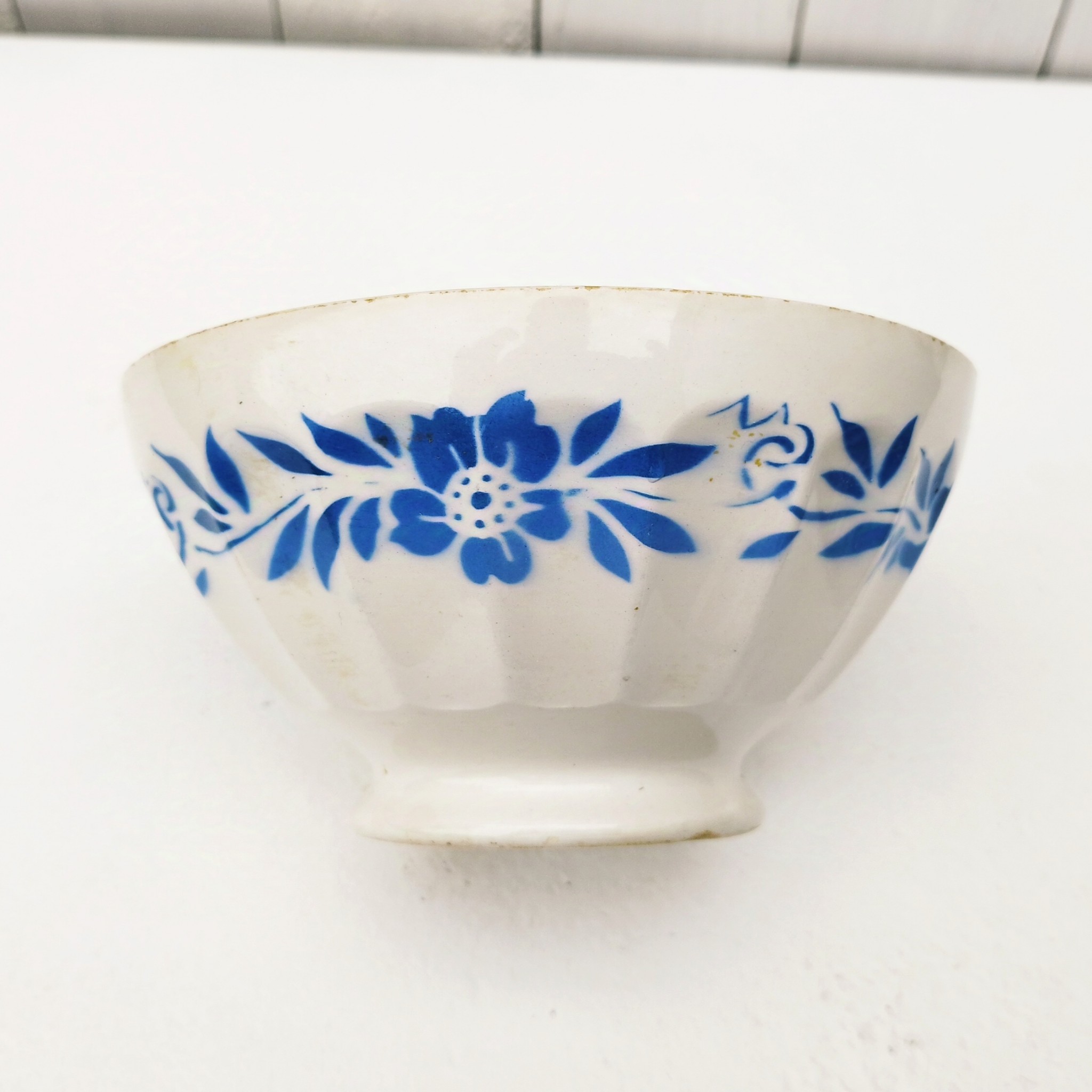Grand bol en faïence, frise florale bleue Petites usures au col,  tâches et rayures à l'intérieur. Etat d'usage Hauteur : 9,5 cm Diamètre : 18 cm