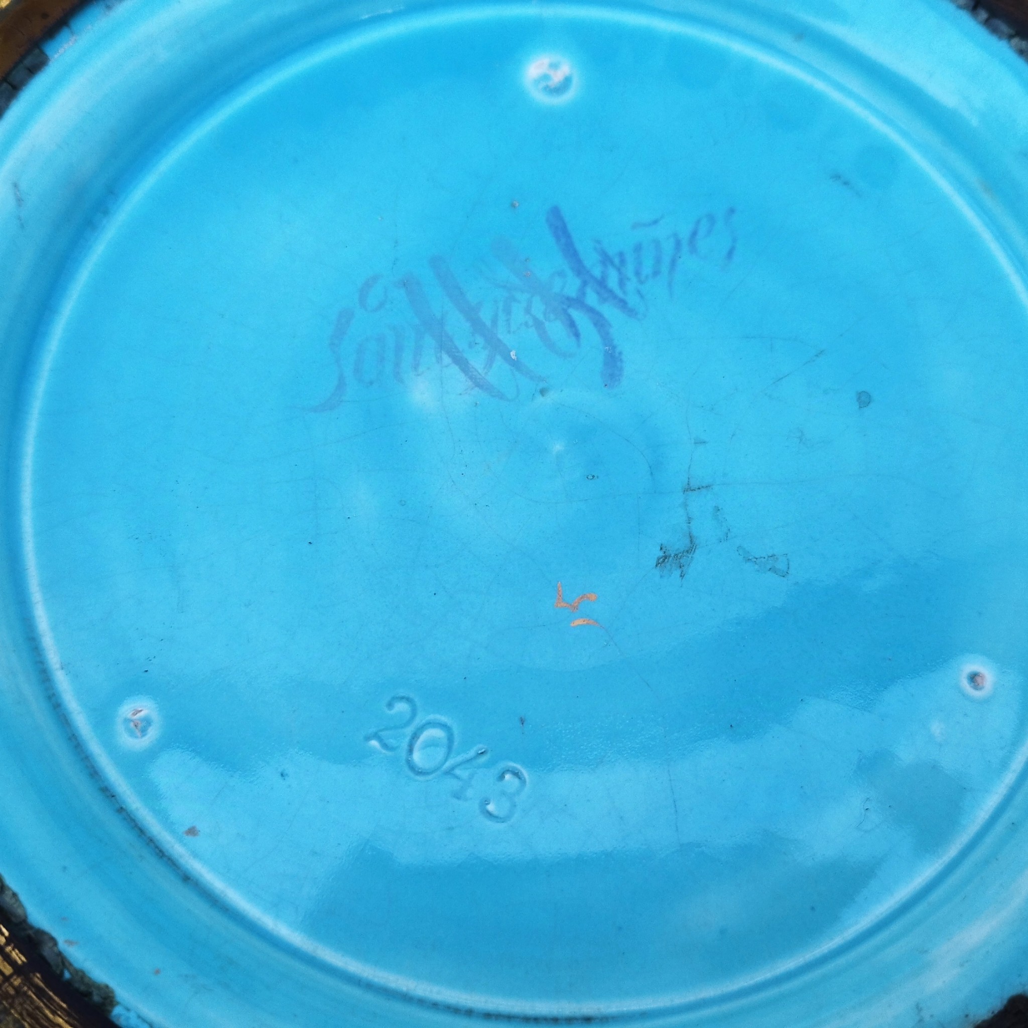 Grand cache-pot ou jardinière en céramique de Sarreguemines numéro 2048. Cerclé d'une couronne en bronze aux prises formant des lions. Pied tripodes en bronze. Couleurs bien vives. races d'usage à l'intérieur. Très bon état. Hauteur max  : 40 cm Diamètre : 25 cm