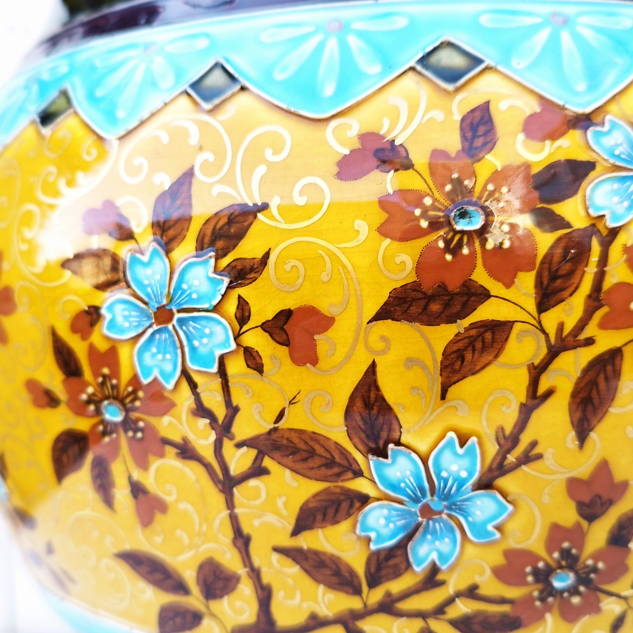 Grand cache-pot ou jardinière en céramique de Sarreguemines numéro 2048. Cerclé d'une couronne en bronze aux prises formant des lions. Pied tripodes en bronze. Couleurs bien vives. races d'usage à l'intérieur. Très bon état. Hauteur max  : 40 cm Diamètre : 25 cm