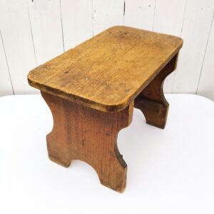 Marche pied ou tabouret  bas, à la forme d'un banc de ferme. En bois patiné. Bon état général. Hauteur : 27 cm Dimensions : 40 x 21,5 cm