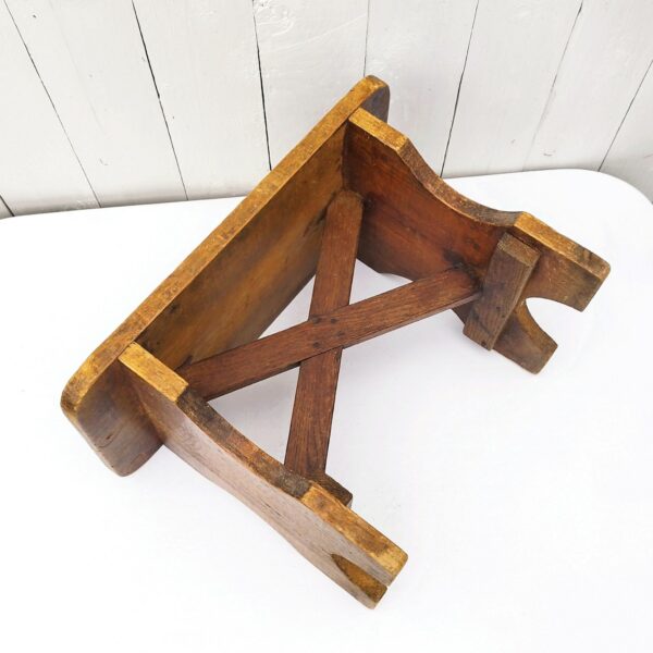 Marche pied ou tabouret  bas, à la forme d'un banc de ferme. En bois patiné. Bon état général. Hauteur : 27 cm Dimensions : 40 x 21,5 cm