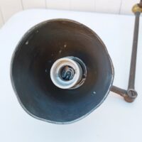 Lampe industrielle d’atelier datant des années 60. Deux bras articulés ( 34 cm et 11 cm). L'interrupteur d'origine sur le globe est HS mais électrification refaite avec interrupteur sur le fil. Traces de corrosion sur la lampe, des enfoncements sur le globe. Dans son jus Longueur max:  60 cm.