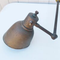 Lampe industrielle d’atelier datant des années 60. Deux bras articulés ( 34 cm et 11 cm). L'interrupteur d'origine sur le globe est HS mais électrification refaite avec interrupteur sur le fil. Traces de corrosion sur la lampe, des enfoncements sur le globe. Dans son jus Longueur max:  60 cm.