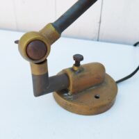 Lampe industrielle d’atelier datant des années 60. Deux bras articulés ( 34 cm et 11 cm). L'interrupteur d'origine sur le globe est HS mais électrification refaite avec interrupteur sur le fil. Traces de corrosion sur la lampe, des enfoncements sur le globe. Dans son jus Longueur max:  60 cm.