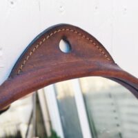 Miroir rond gainé de cuir, piqûre sellier sur l'attache , toile de jute de protection à l'arrière. Petites traces et rayures d'usage sur le miroir. Bon état général Diamètre : 35,5 cm