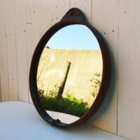 Miroir rond gainé de cuir, piqûre sellier sur l'attache , toile de jute de protection à l'arrière. Petites traces et rayures d'usage sur le miroir. Bon état général Diamètre : 35,5 cm