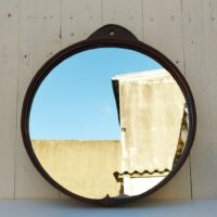 Miroir rond gainé de cuir, piqûre sellier sur l'attache , toile de jute de protection à l'arrière. Petites traces et rayures d'usage sur le miroir. Bon état général Diamètre : 35,5 cm