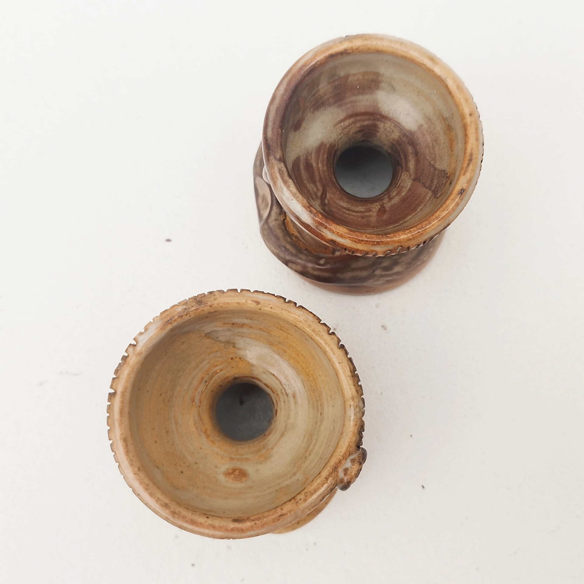 Paire de coquetiers anthropomorphes en céramique par Jacques Pouchain. Ils sont de deux tailles différentes. Excellent état . Hauteur : 5,5 cm  Diamètres : 4,8 et 5,2 cm