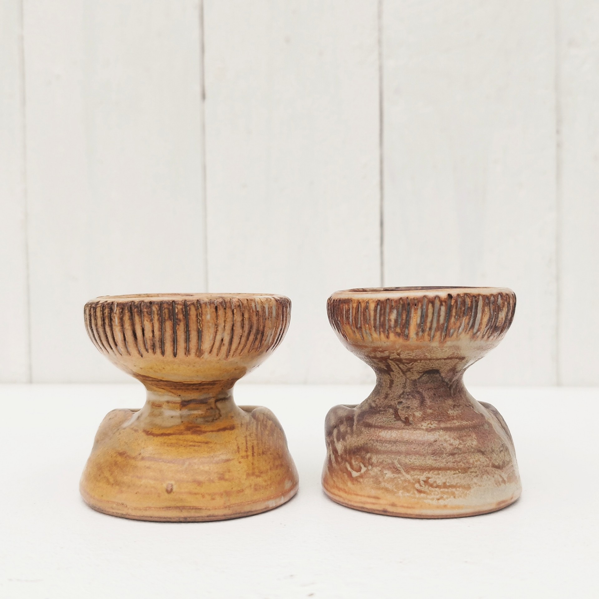 Paire de coquetiers anthropomorphes en céramique par Jacques Pouchain. Ils sont de deux tailles différentes. Excellent état . Hauteur : 5,5 cm  Diamètres : 4,8 et 5,2 cm