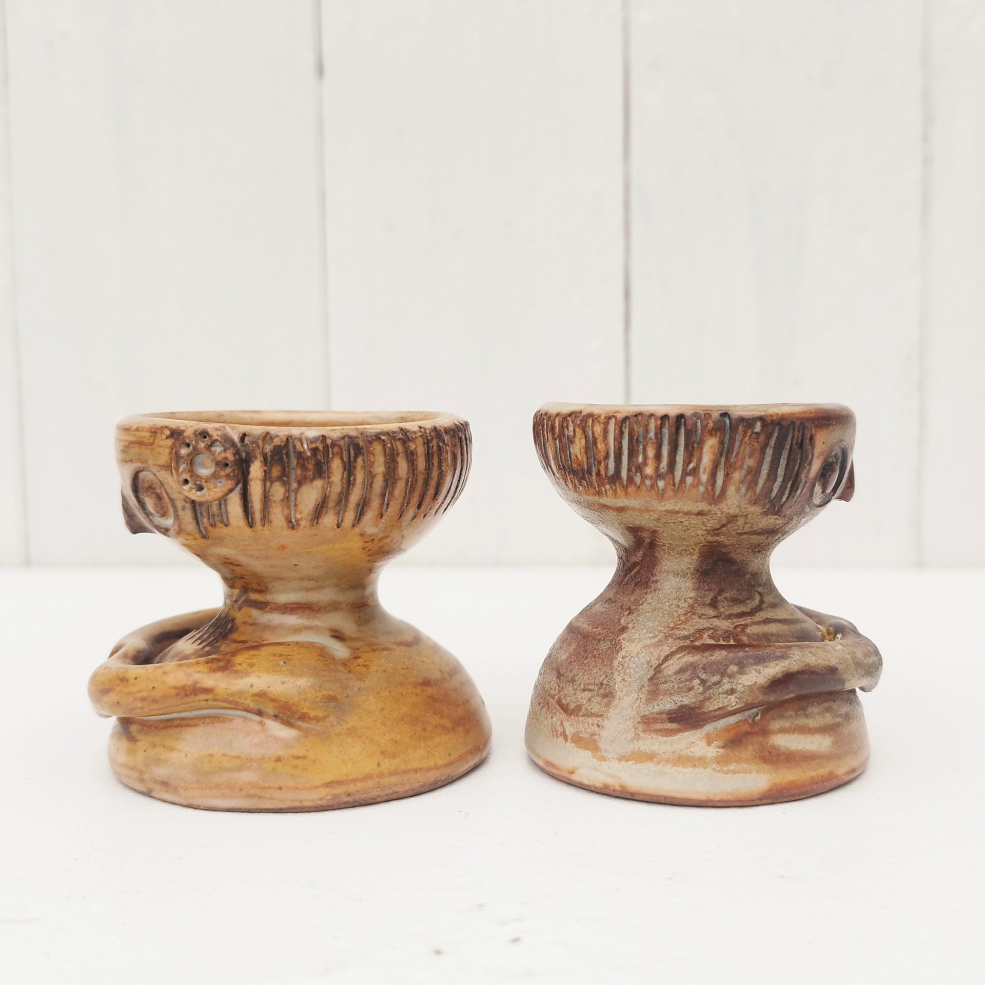 Paire de coquetiers anthropomorphes en céramique par Jacques Pouchain. Ils sont de deux tailles différentes. Excellent état . Hauteur : 5,5 cm  Diamètres : 4,8 et 5,2 cm