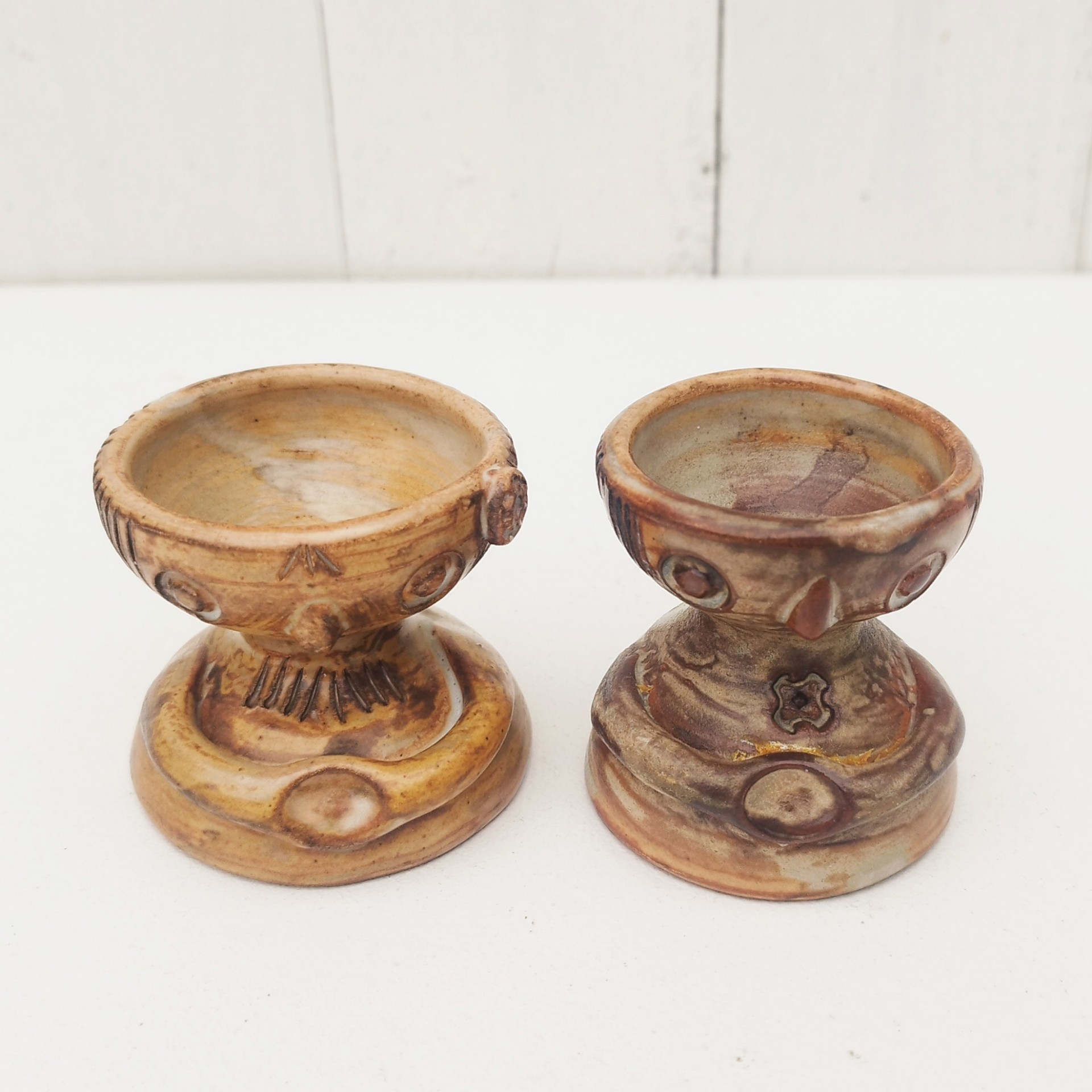 Paire de coquetiers anthropomorphes en céramique par Jacques Pouchain. Ils sont de deux tailles différentes. Excellent état . Hauteur : 5,5 cm  Diamètres : 4,8 et 5,2 cm