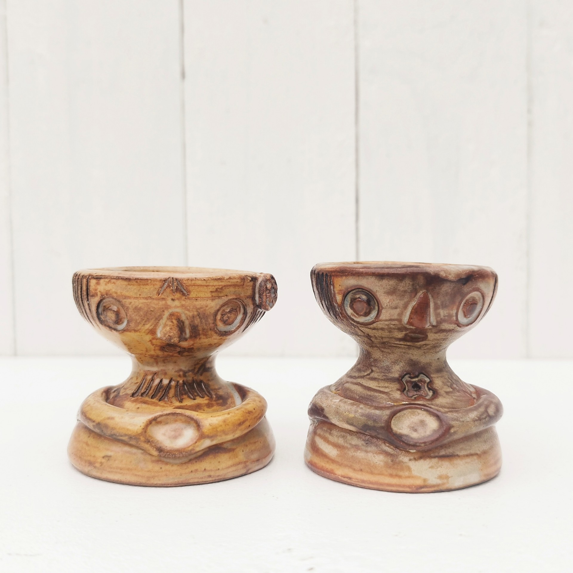 Paire de coquetiers anthropomorphes en céramique par Jacques Pouchain. Ils sont de deux tailles différentes. Excellent état . Hauteur : 5,5 cm  Diamètres : 4,8 et 5,2 cm