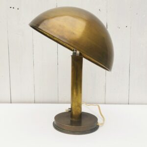 Lampe champignon laiton datant du début XXème. Réflecteur amovible. Traces de vert de gris, et rayures d'usage. Quelques petits chocs. Electrification d'origine. Le bouton poussoir à changer. Non testée Hauteur  : 31 cm Diamètre réflecteur : 25,5 cm