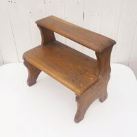 Marche pied deux marches en bois patiné verni. Traces d'usage et d'anciens xylophages. Bon état général. Hauteur : 34 cm Dimensions : 36 x 21 cm