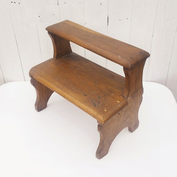 Marche pied deux marches en bois patiné verni. Traces d'usage et d'anciens xylophages. Bon état général. Hauteur : 34 cm Dimensions : 36 x 21 cm