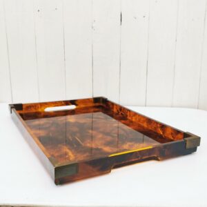 Plateau de service en lucite ( plexiglas épais) écailles de tortue , avec encoignure en laiton. Attribué à la maison Dior dans les années 70. home collection. Traces et rayures d'usage.  Bon état général. Dimensions : 44,5 x 31 x 3,5 cm