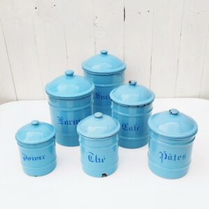 Série de six pots à épices, en tôle émaillée de couleur bleue. Sucre, Farine, café, pâtes, thés et poivre . Des éclats sur les bords des cols et sur le bas des pots . Des éclats d'émail sur les couvercles. Bon état général au vu de leur age. Hauteur et diamètre max : 16 et 14 cm Hauteur et diamètre min : 10 et 8,5 cm