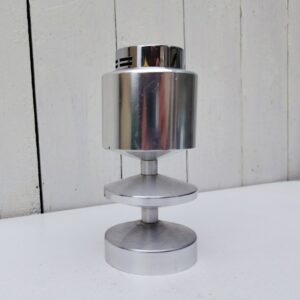 Briquet de table en aluminium brossé au design typique des années 70. Briquet rechargeable, fonctionne très bien. Petites rayures d'usage sans gravité et petites taches, feutre rouge sur le dessous . Lamelle du fond qui détache. Bon état général Hauteur : 15 cm Diamètre : 6,5 cm