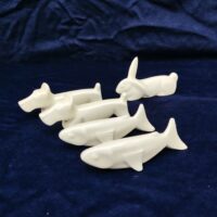 Cinq porte couteaux en porcelaine blanche représentant deux chiens , deux poisson et un lapin. Bon état général. Longueur : 10 cm