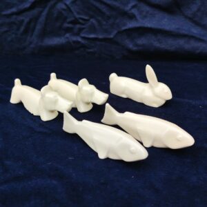Cinq porte couteaux en porcelaine blanche représentant deux chiens , deux poisson et un lapin. Bon état général. Longueur : 10 cm