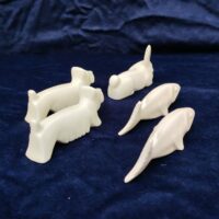 Cinq porte couteaux en porcelaine blanche représentant deux chiens , deux poisson et un lapin. Bon état général. Longueur : 10 cm