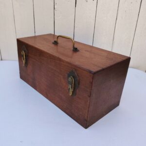 Boite coffre en bois  vernis  avec Poignée et fermetures en laiton. rayures et petites taches d'usage. Bon état général Dimensions : 37,5 x 17 cm Hauteur fermée : 17,5 cm