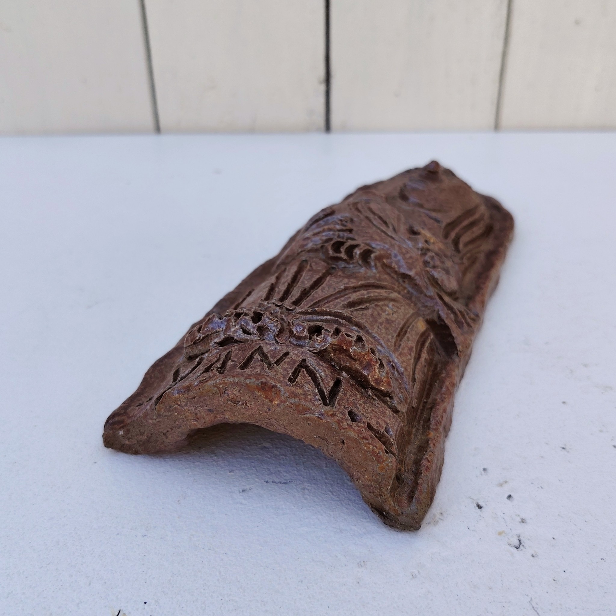 Sculpture anthropomorphe représenatnt Saint jean avec un oiseau en terre cuite vernisée, par Raymond Debiève. Un trou sur le haut pour l'accrocher au mur. Signé et daté en creux.